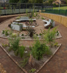 An image of a landscaping job we did with a small round flower bed and seating area