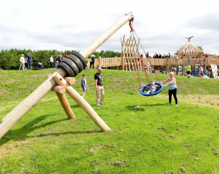 Child playing on a swing being pushed by another person